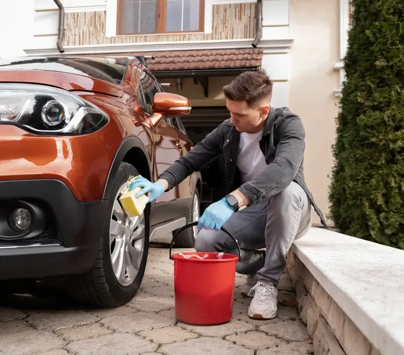 Lavage auto à domicile Grisy-les-Plâtres : professionnel intervenant sur un véhicule